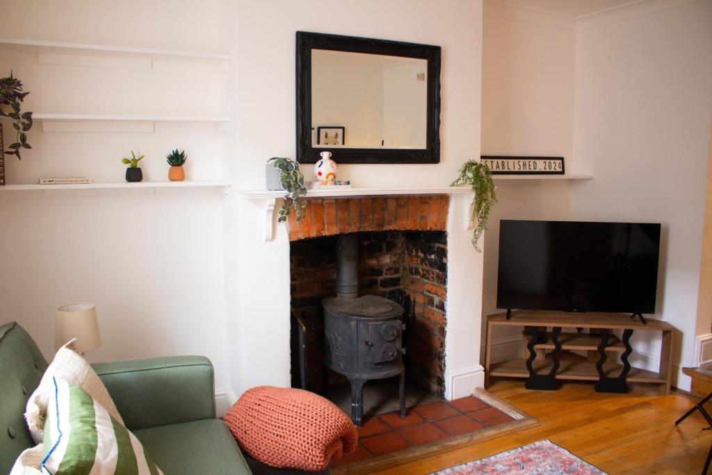 a living room with a fireplace and a television at Characterful Cottage - Sleeps 6 - Parking - High Street in Marlborough