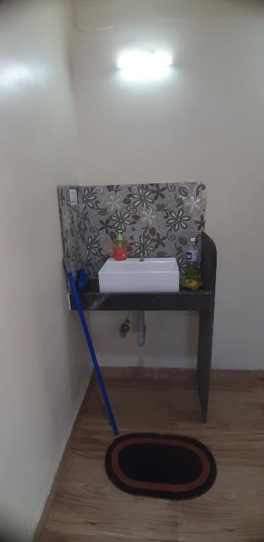 uma mesa com uma esfregona e um lavatório na parede em Hotel The Grand em Mahabaleshwar
