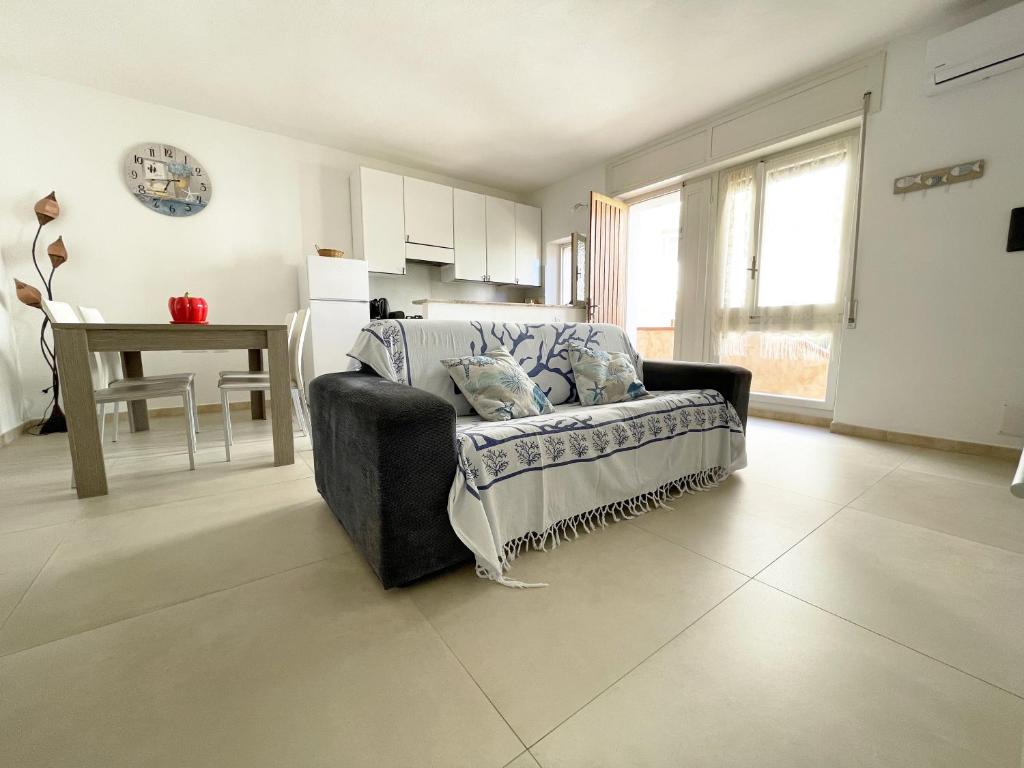 un soggiorno con divano e tavolo di Nuovo Appartamento Ristrutturato in Corte Interna a La Maddalena