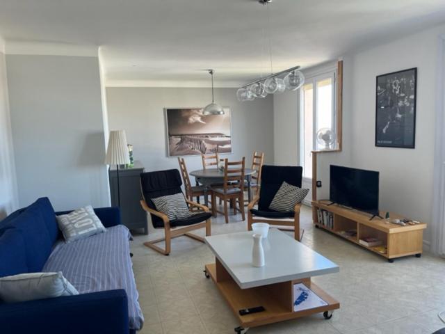 un salon avec un canapé, des chaises et une table dans l'établissement T3 Corniche Sète Rare, à Sète