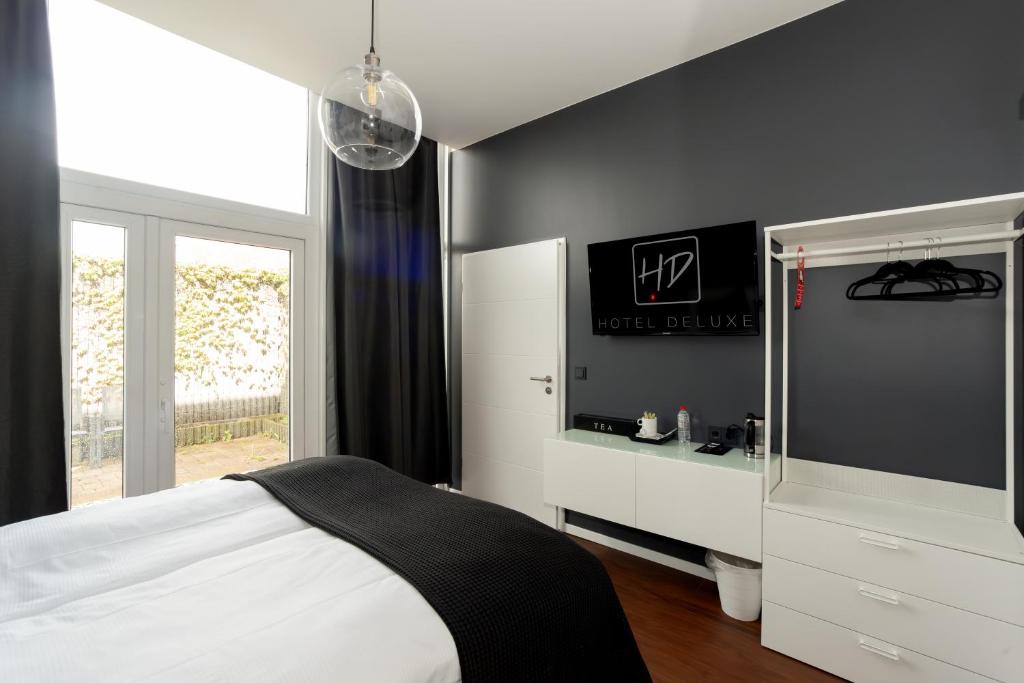 Ένα ή περισσότερα κρεβάτια σε δωμάτιο στο Hotel Deluxe