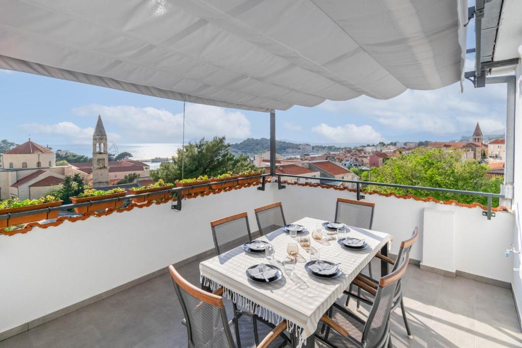 a table on the balcony with a view of the city at Apartman L&L in Makarska
