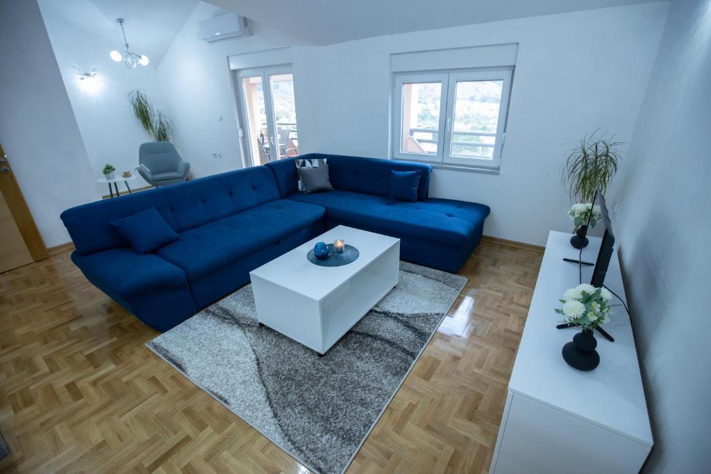 トレビニェにあるApartman Jelićのリビングルーム(青いソファ、テーブル付)