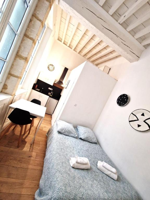 un salon avec un lit et une table dans l'établissement Joli studio à deux pas de la place du forum, à Arles