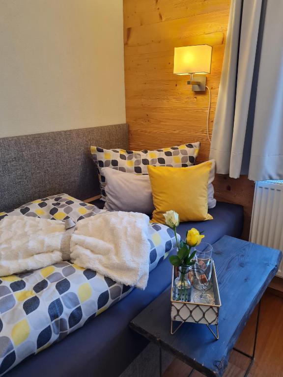 a living room with a blue couch and a table at Ferienwohnung Oase in Peißenberg
