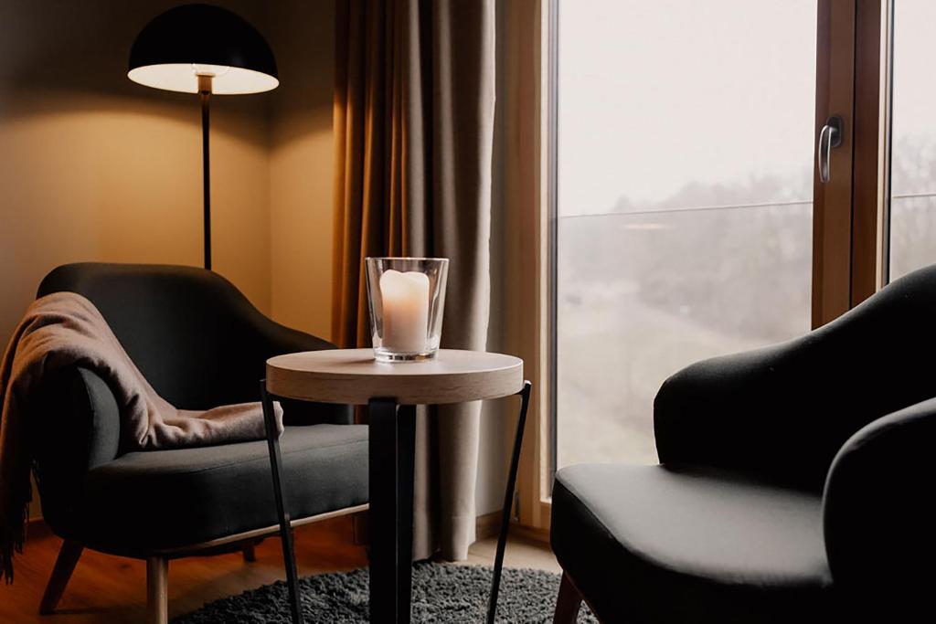 モールバッハにある2tHEIMAT - Hotel & Restaurantの窓際のテーブルにキャンドルが備わるお部屋