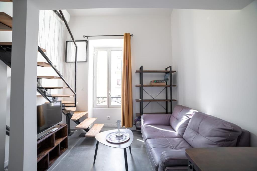 ein Wohnzimmer mit einem Sofa und einem TV in der Unterkunft PETIT DUPLEX - Nouveau duplex central avec wifi et clim pour 2 in Antibes