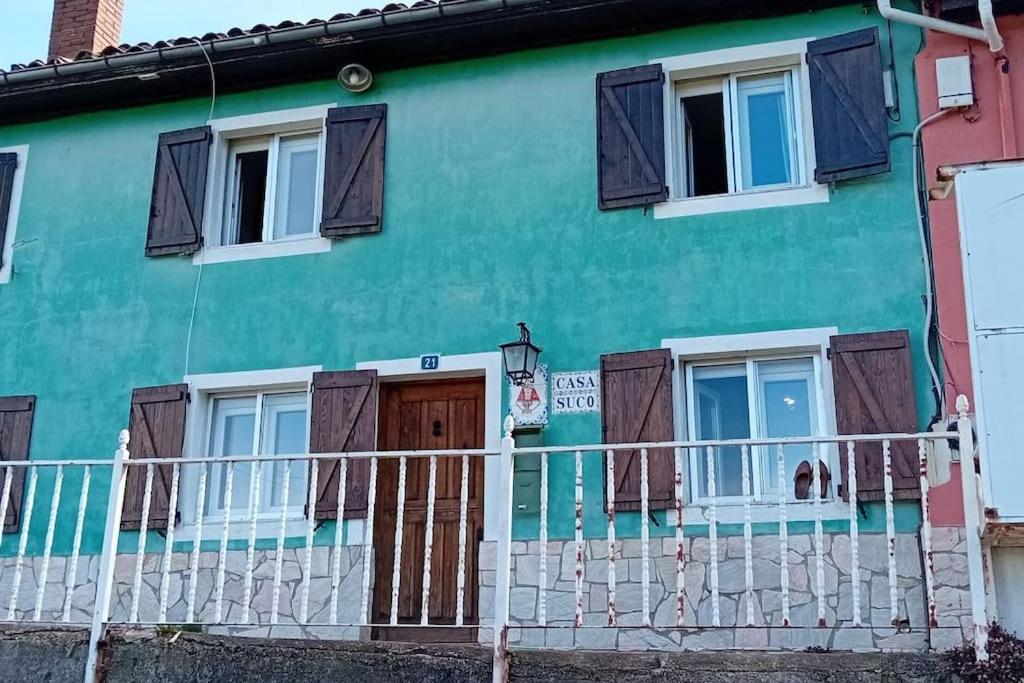 ein grünes Haus mit einem weißen Zaun davor in der Unterkunft Casa rural en Asturias in Bimenes