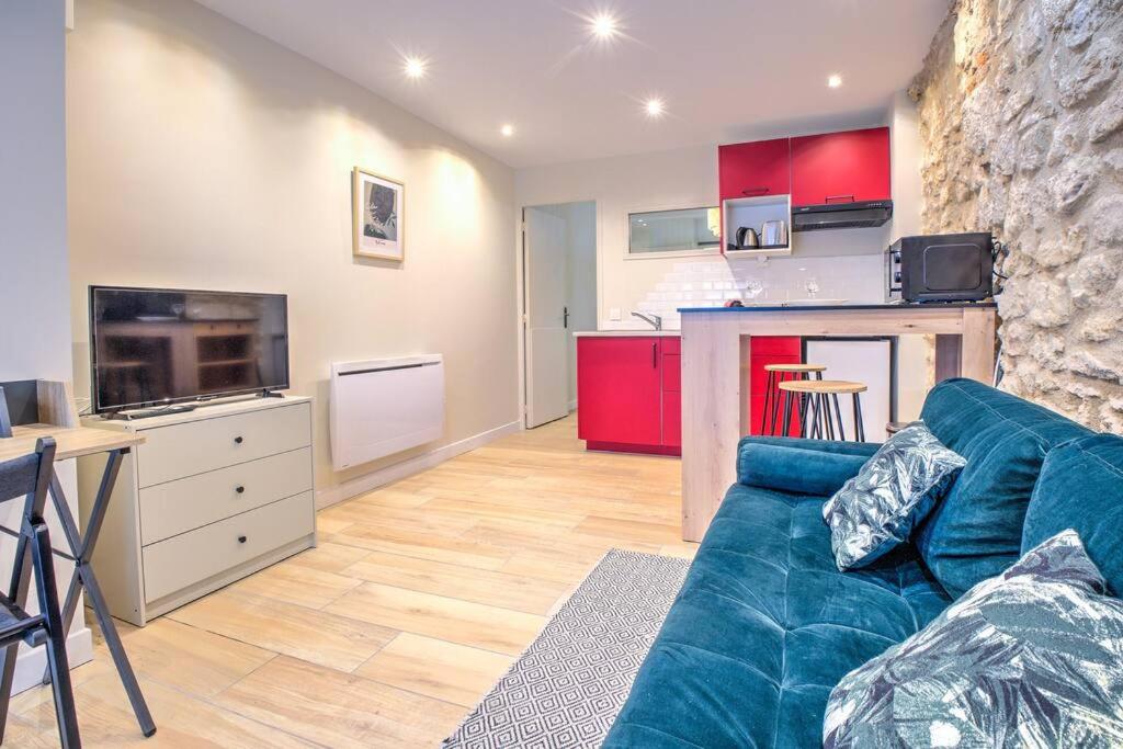 un salon avec un canapé bleu et une cuisine dans l'établissement L'auberge rit !, à Périgueux