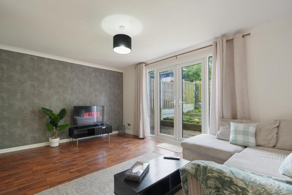 Contractor accommodation في Heeley: غرفة معيشة مع أريكة وتلفزيون