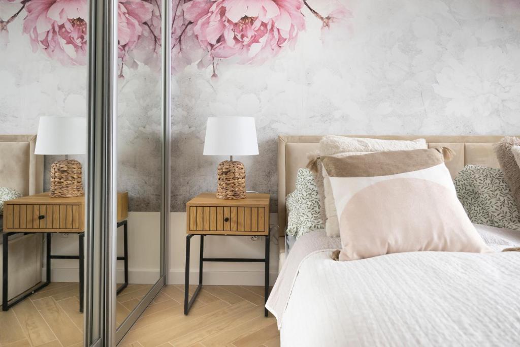 a bedroom with pink flowers on the wall at APARTAMENT BOHO in Gdańsk