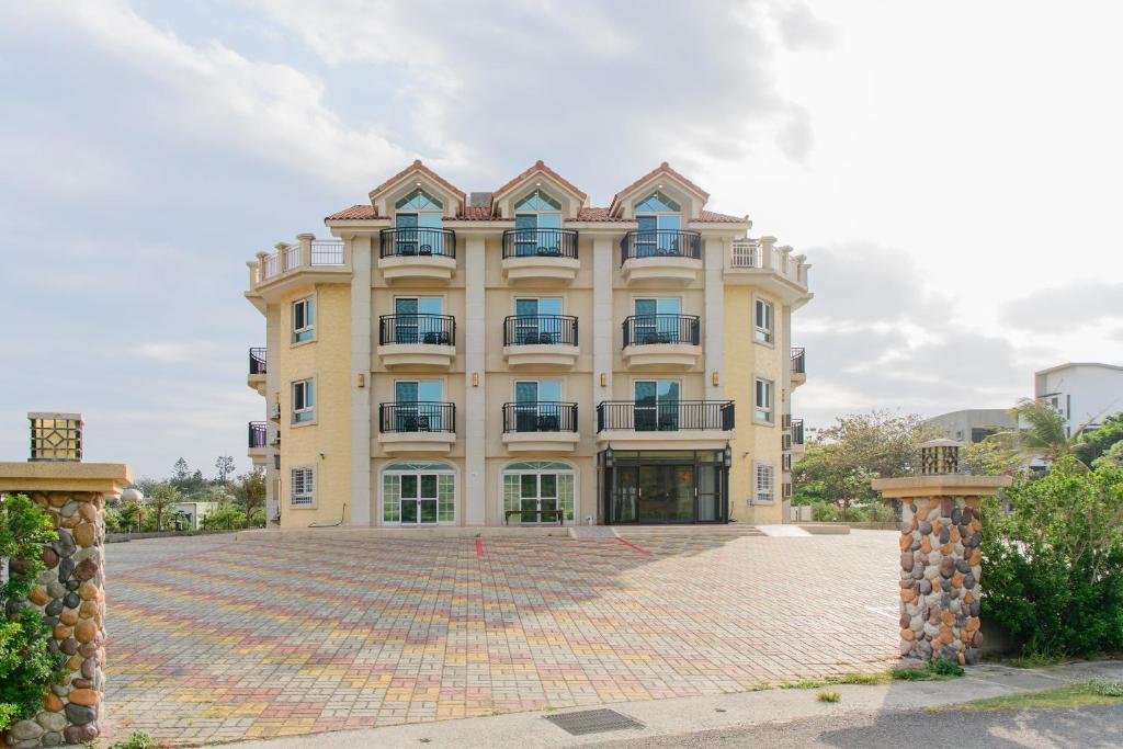 a large yellow building with a brick courtyard at Island on the Sea in Kenting