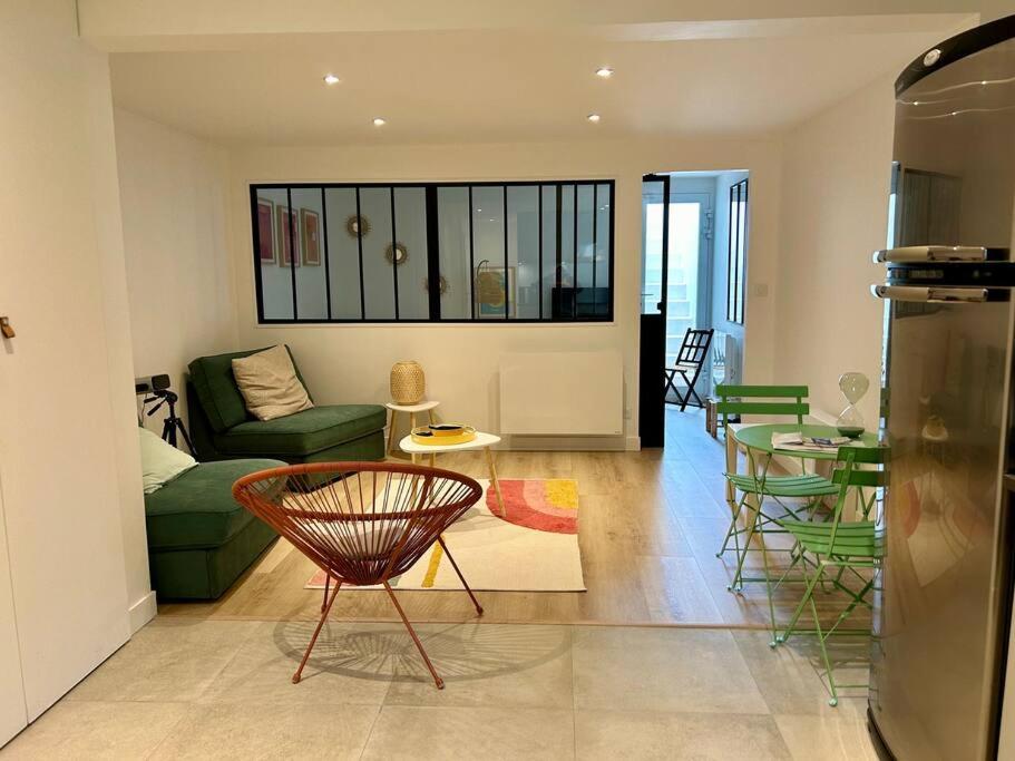 a living room with a couch and a table and chairs at Nice new apartment with direct access a big garden in Saint-Germain-en-Laye