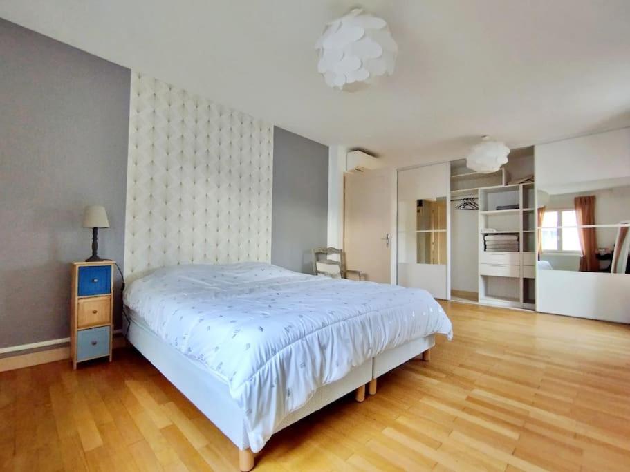 une chambre avec un lit blanc et un parquet dans l'établissement Villa Beaumont, à Bourges