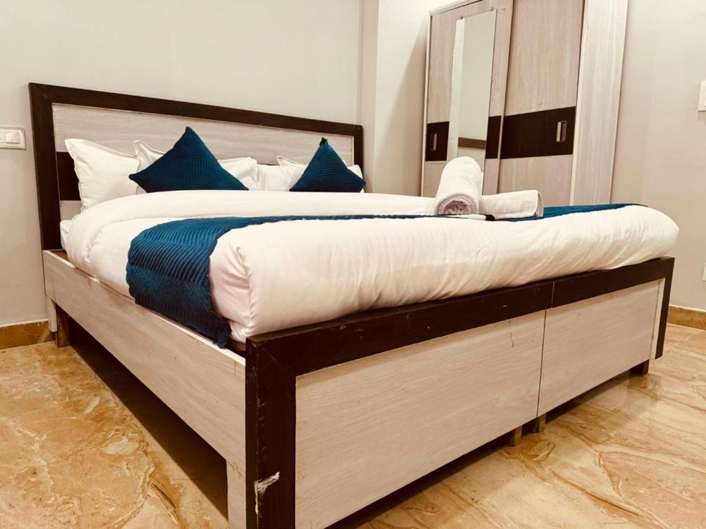 a bedroom with a large bed with blue pillows at Aston Hills Rooms & Cottages Tapovan in Rishīkesh