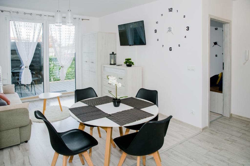 a dining room with a table and black chairs at Apartament Reda in Reda