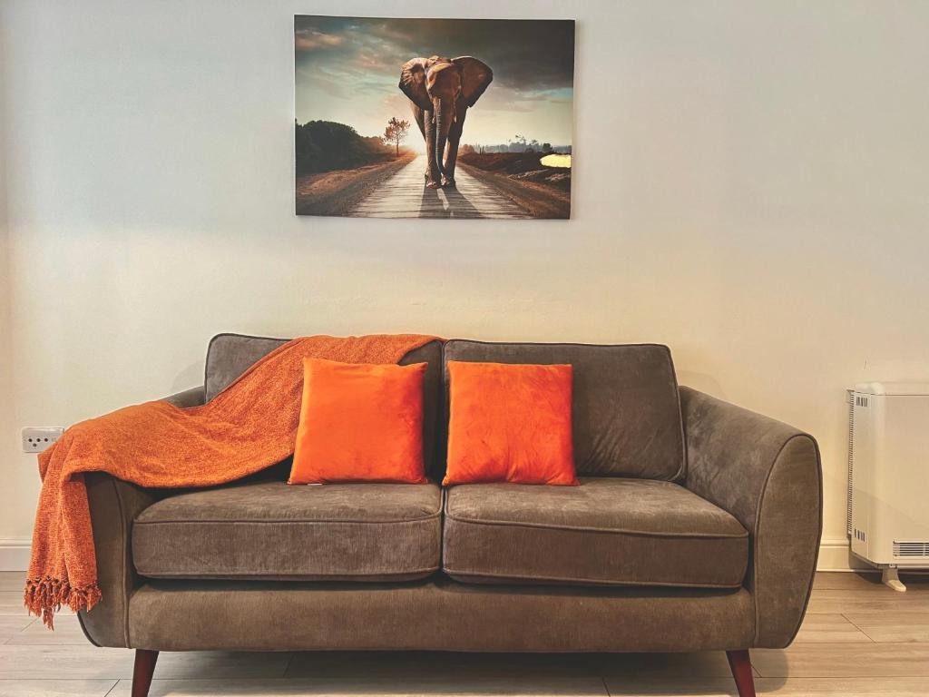 a couch with an elephant painting on the wall at Shazeal Apartment Tipton in Ocker Hill