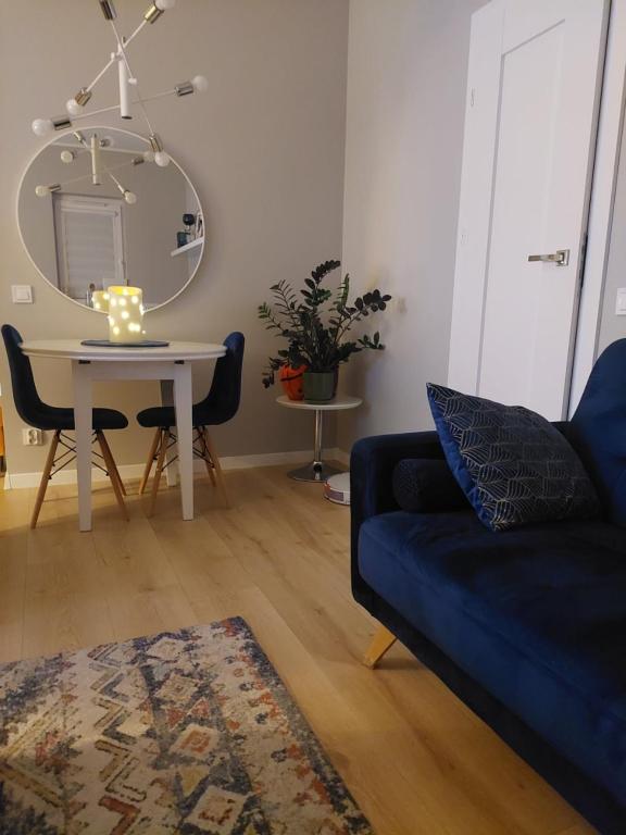 uma sala de estar com um sofá e uma mesa com um espelho em Apartament Ząbki em Zabki