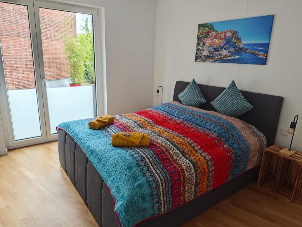 a bedroom with a bed with a colorful blanket on it at *1A Lage/Top Anbindung/4 Pers./Tiefgarage/Smart-TV* in Cologne
