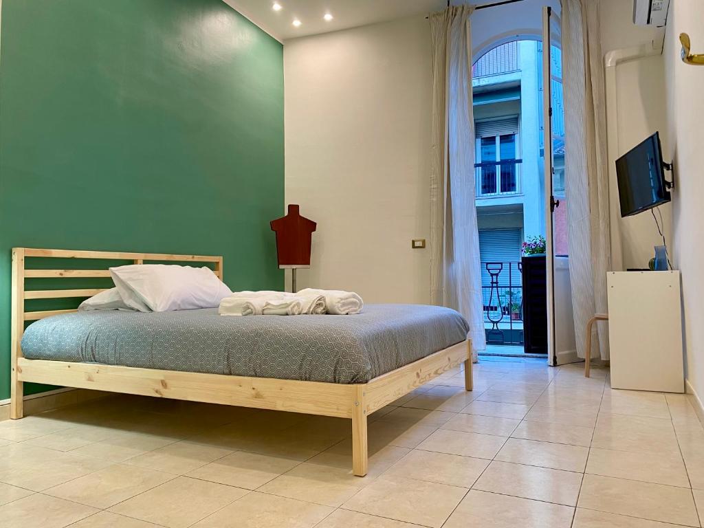 Un dormitorio con una cama con una pared verde. en Cinque Terre Casa Gina La Spezia, en La Spezia