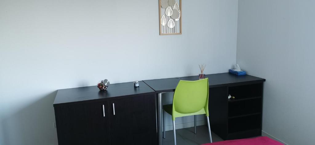 Cette chambre comprend un bureau avec une chaise verte. dans l'établissement Studio, à Avignon