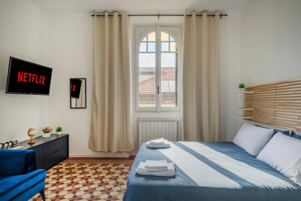 ein Schlafzimmer mit einem blauen Bett und einem Fenster in der Unterkunft MONZA centro-Milano [Casa di Fronte alla Stazione] in Monza