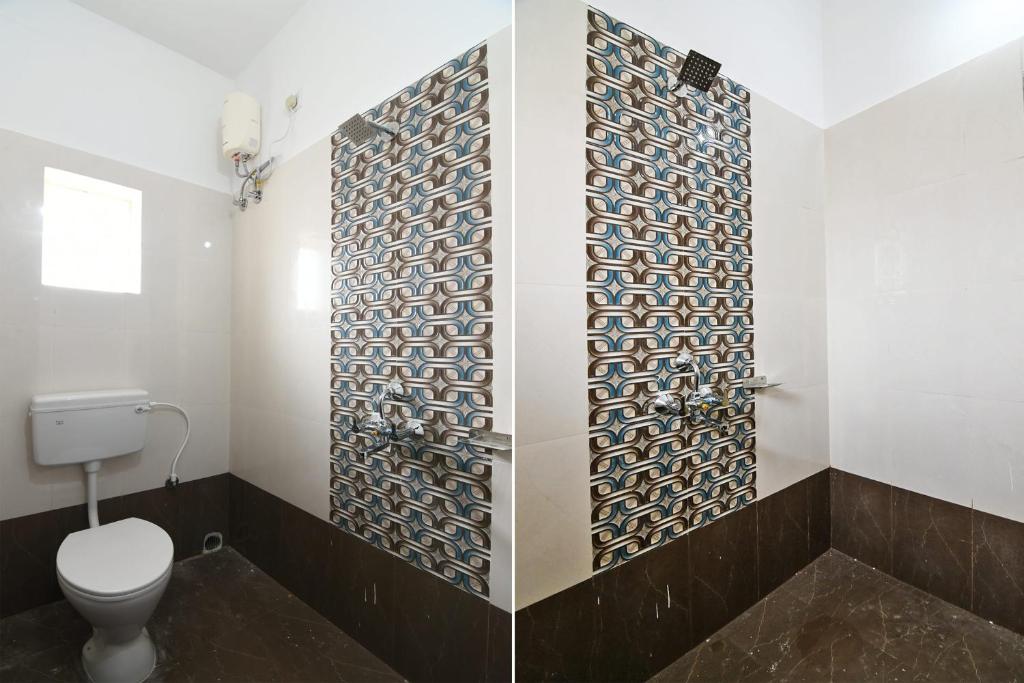 a bathroom with a toilet and a tile wall at OYO Hotel Bijaya Premium in Bhubaneshwar