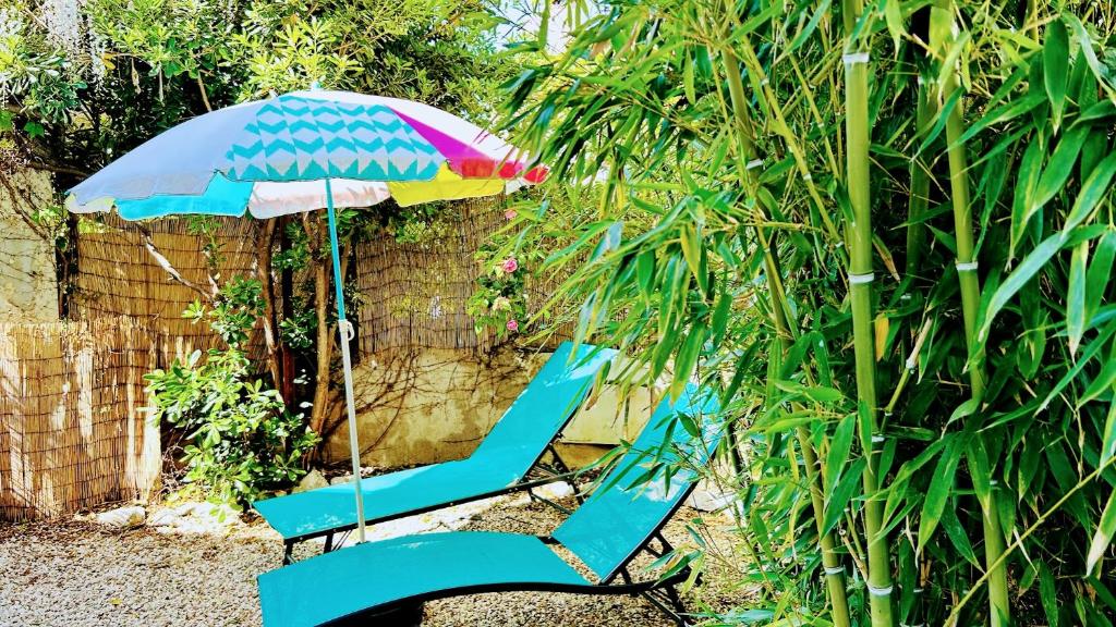 une chaise bleue avec un parasol dans le jardin dans l'établissement Serenity - Garden Calm & Air Conditioning Downtown, à Saint-Laurent-du-Var