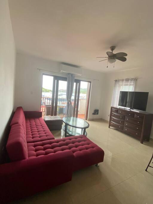 sala de estar con sofá rojo y mesa en 2 bedrooms on marina with terrace., en Simpson Bay
