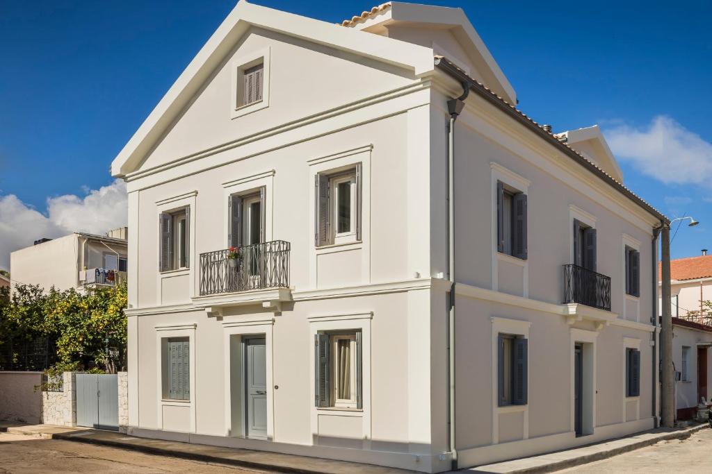 a white building with a balcony on a street at Marissa's Elegant retreats in Argostoli