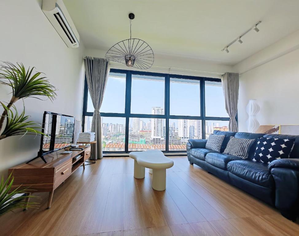 a living room with a blue couch and a large window at Urban Suites Georgetown New Condo City View 158 in Jelutong