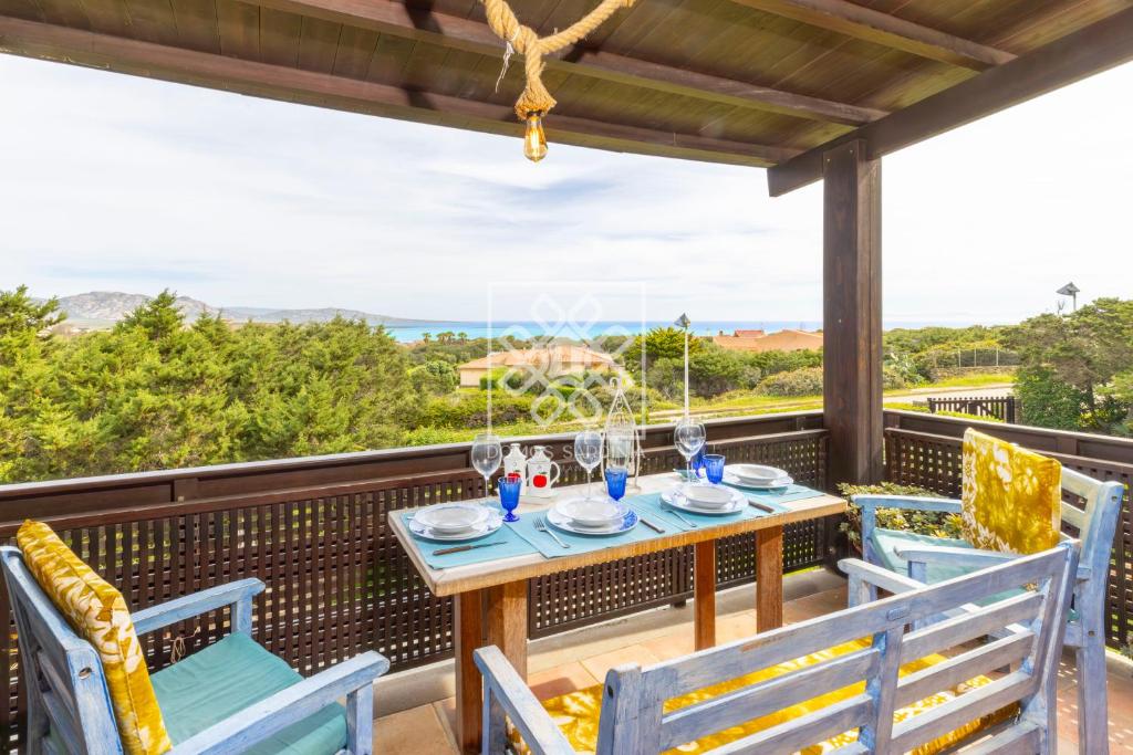una mesa y sillas en un balcón con vistas al océano en Casa Maria Grazia, en Stintino