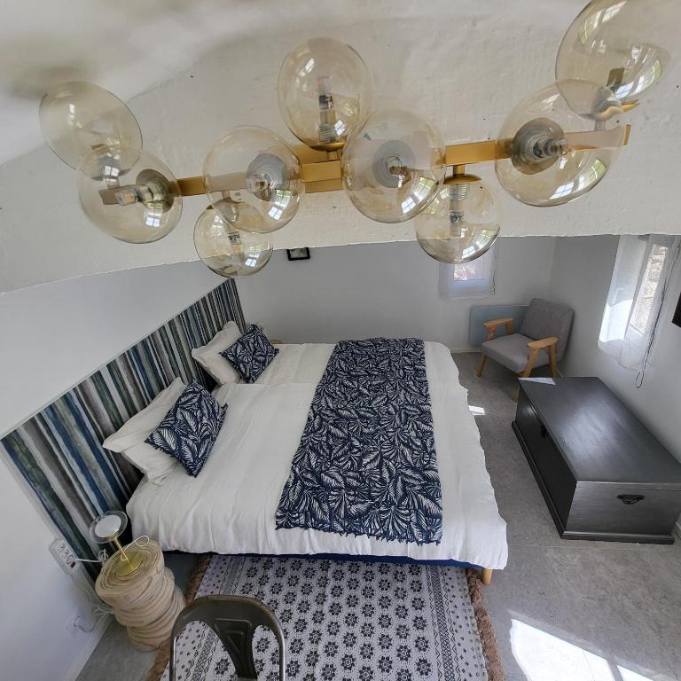 a bedroom with a bed and a chandelier at Les Pierres de Cézaire in Saint-Cézaire-sur-Siagne