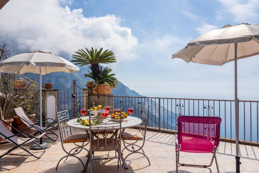 Una mesa y sillas en un balcón con vista al mar. en Villa Lavinia Nocelle, en Positano