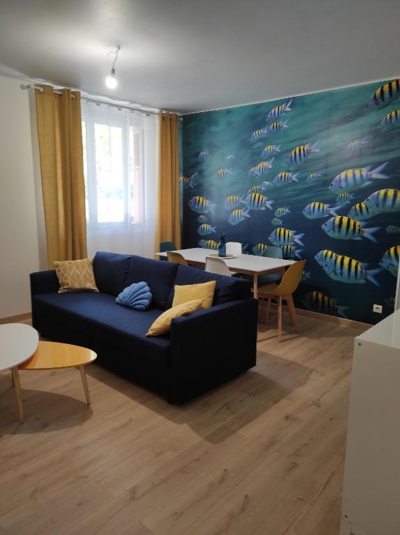 un salon avec un canapé bleu et des tables dans l'établissement Charmant T3 climatisation parking alarme, à Toulon