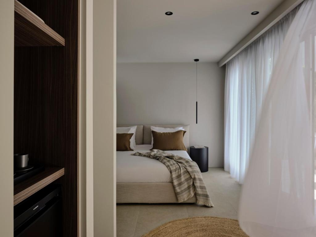 1 dormitorio con cama y ventana en Bond Smart Living Suites en Atenas