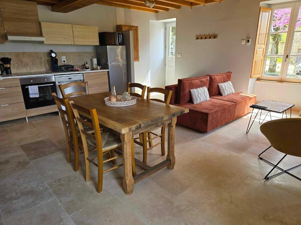 cocina y sala de estar con mesa de madera y sillas en Gite au pied de la Colline en Vézelay