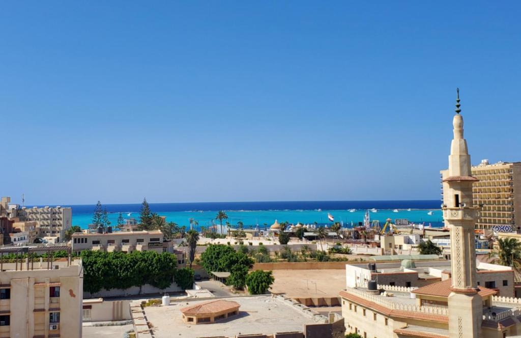 a view of a city with a mosque and the ocean at Adriatica Hotel Marsa Matrouh in Marsa Matruh