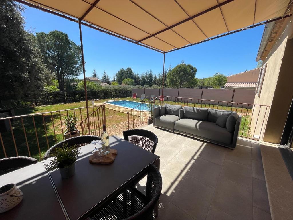 a patio with a couch and a table at Villa en Provence in Saint-Saturnin-lès-Apt