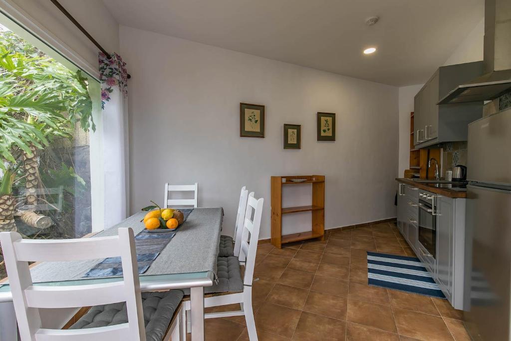 a kitchen and dining room with a table and chairs at Strelitzia Apartament in Santa Úrsula