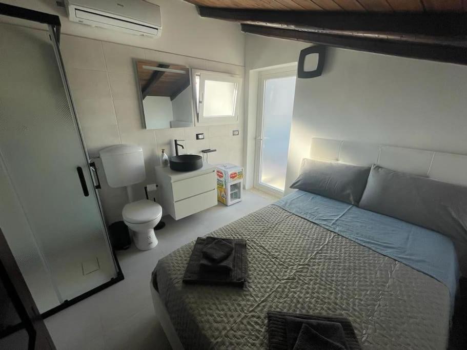 a bedroom with a bed and a bathroom with a sink at Mini luxury suite Ortea in Siracusa