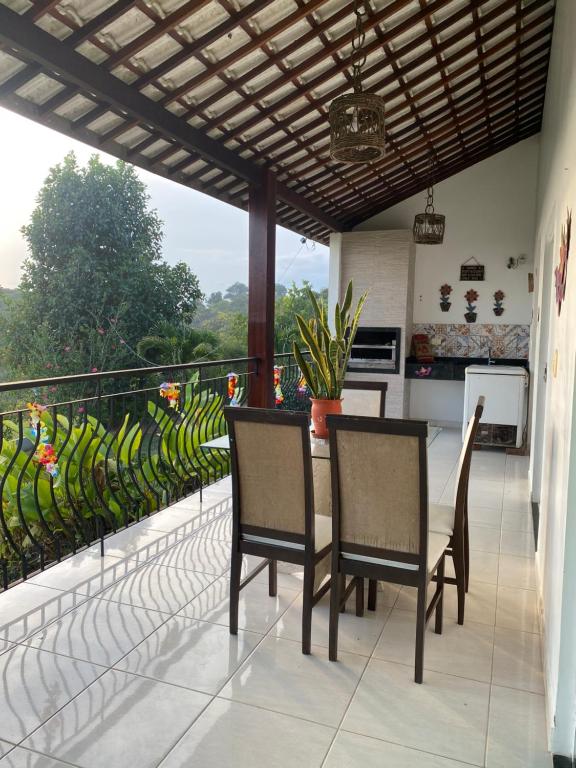 a balcony with a table and chairs and a kitchen at Casa de Vidro Sairé in Recife