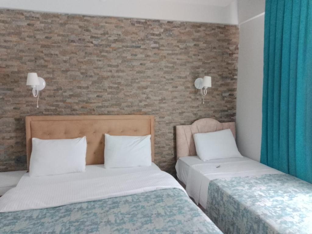 twee bedden in een kamer met blauwe gordijnen bij The Cotton House Hotel in Pamukkale