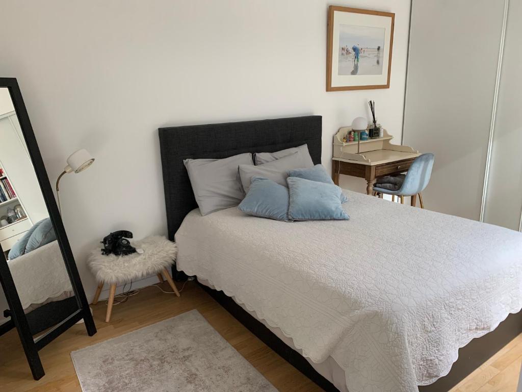 een slaapkamer met een bed, een bureau en een spiegel bij Chambres dans maison d'architecte in Suresnes