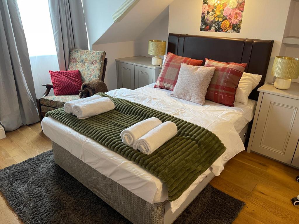 a bedroom with a large bed with towels on it at Luxury Ensuite Rooms in Surbiton, An easy acess to central London in Surbiton