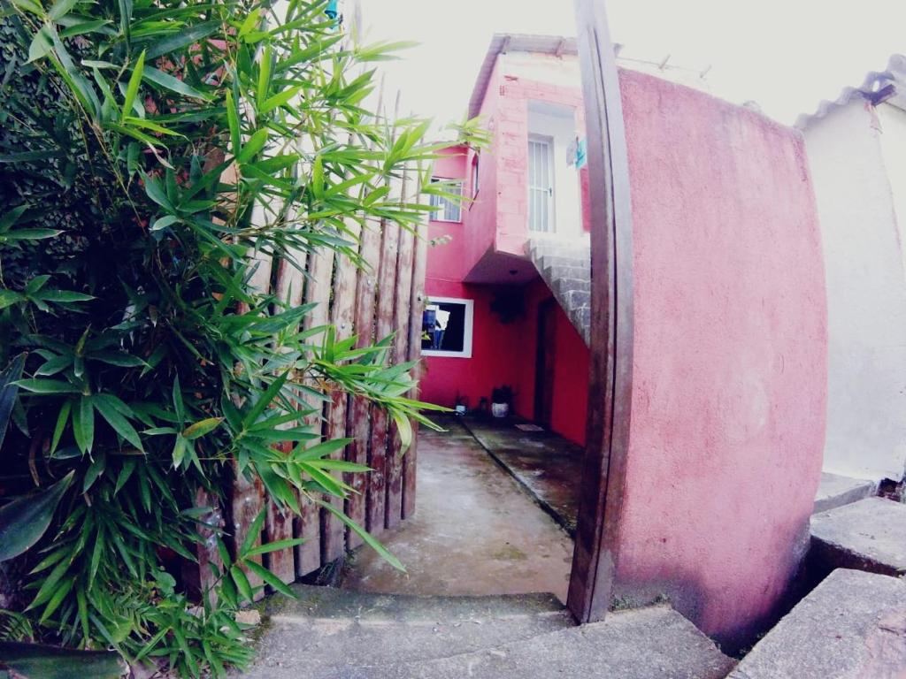 um beco com um edifício vermelho e plantas em Casa do Aventureiro em Abraão