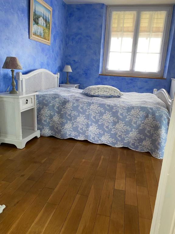 1 dormitorio azul con 1 cama y suelo de madera en Maison de Charme, en Champs-Sur-Marne