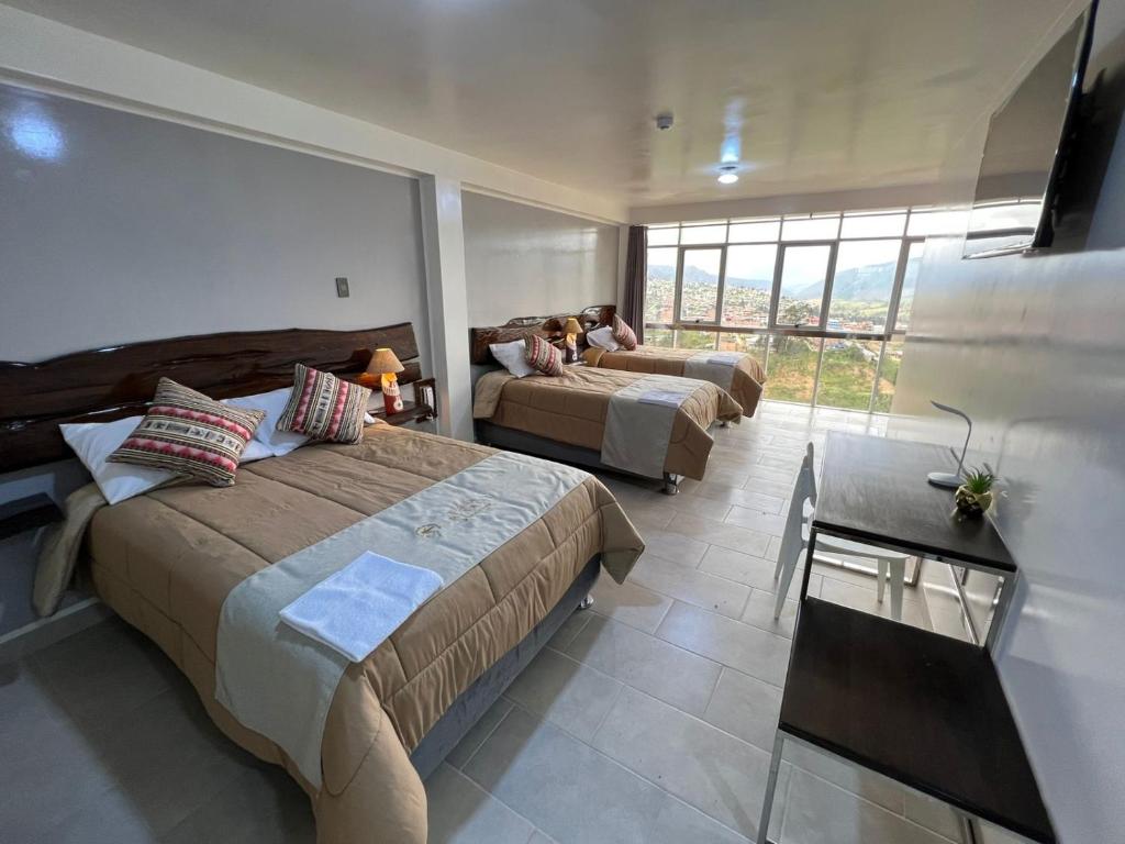 um quarto de hotel com duas camas e uma grande janela em Terra Imperial em Chachapoyas