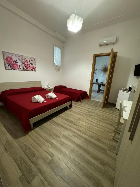 um quarto com uma cama vermelha e um sofá em Carpentry em Uggiano la Chiesa