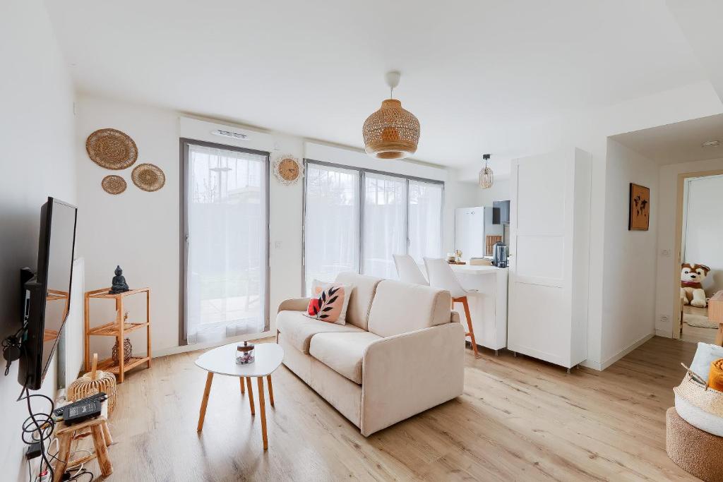 un salon avec un canapé blanc et une table dans l'établissement Charmant 2 pièces avec Terrasse Proche Transport, à Épinay-sur-Seine